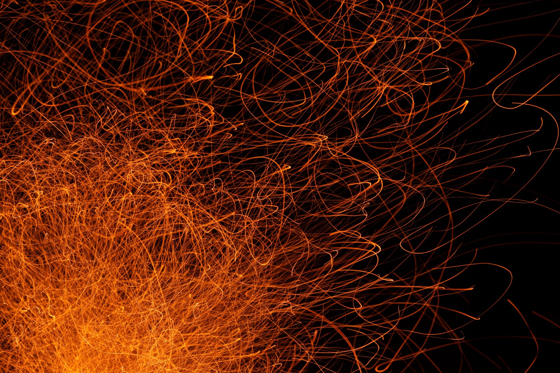 Abstract HD PC desktop wallpaper featuring dynamic, tangled orange lines on a black background, creating an energetic and chaotic visual effect.
