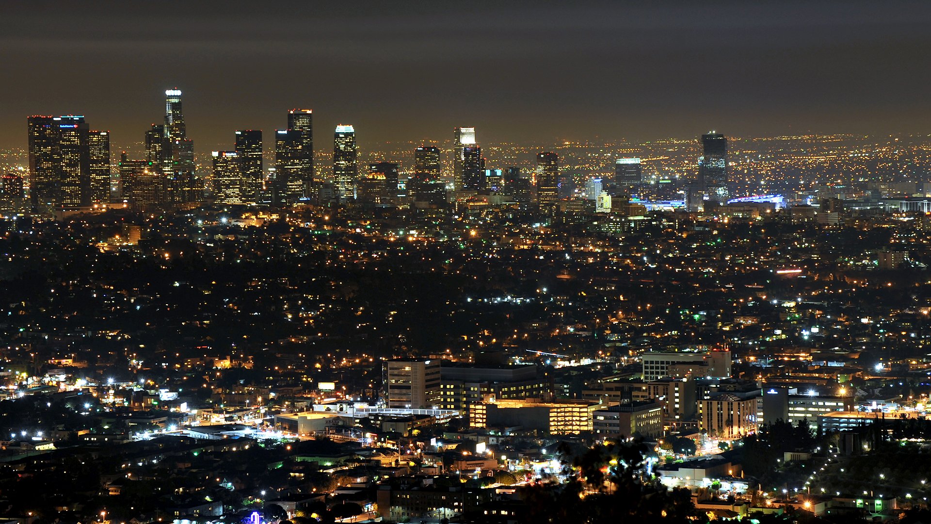 HD PC desktop wallpaper: night panorama of Los Angeles, man-made skyline and sprawling city lights glittering across the horizon.