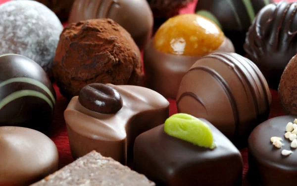 A close-up of assorted chocolates, showcasing rich textures and various shapes. This 4K Ultra HD image serves as an appetizing desktop wallpaper and background.