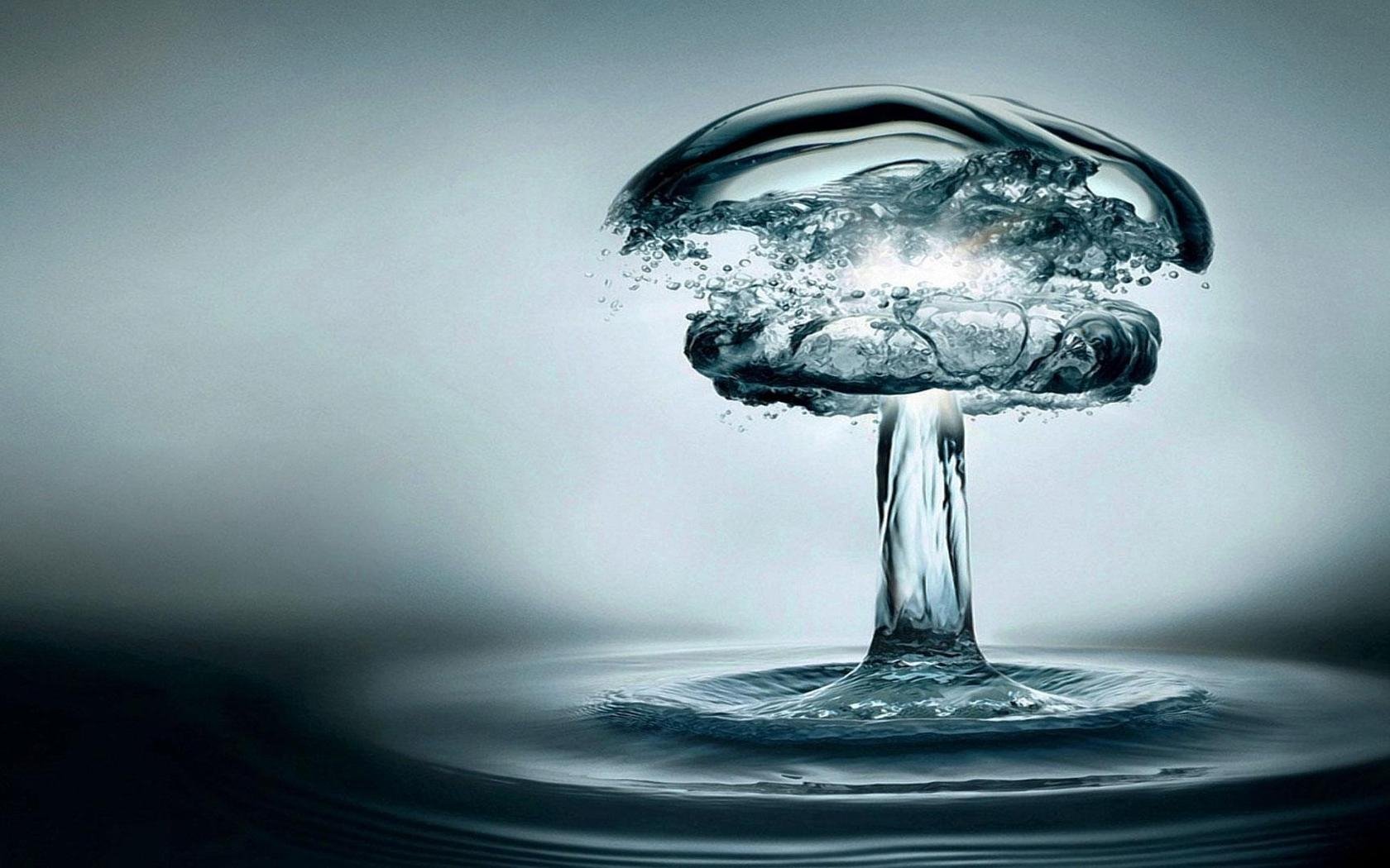 Artistic HD desktop wallpaper depicting a water splash shaped like a mushroom cloud, captured in crisp detail against a soft gray background.