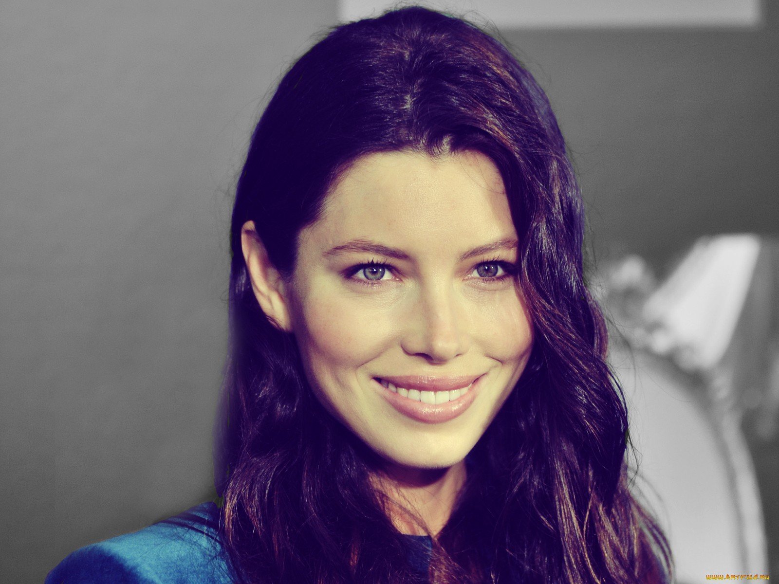 HD wallpaper featuring Jessica Biel, showcasing her radiant smile and long dark hair against a softly blurred background. A captivating desktop backdrop for fans.