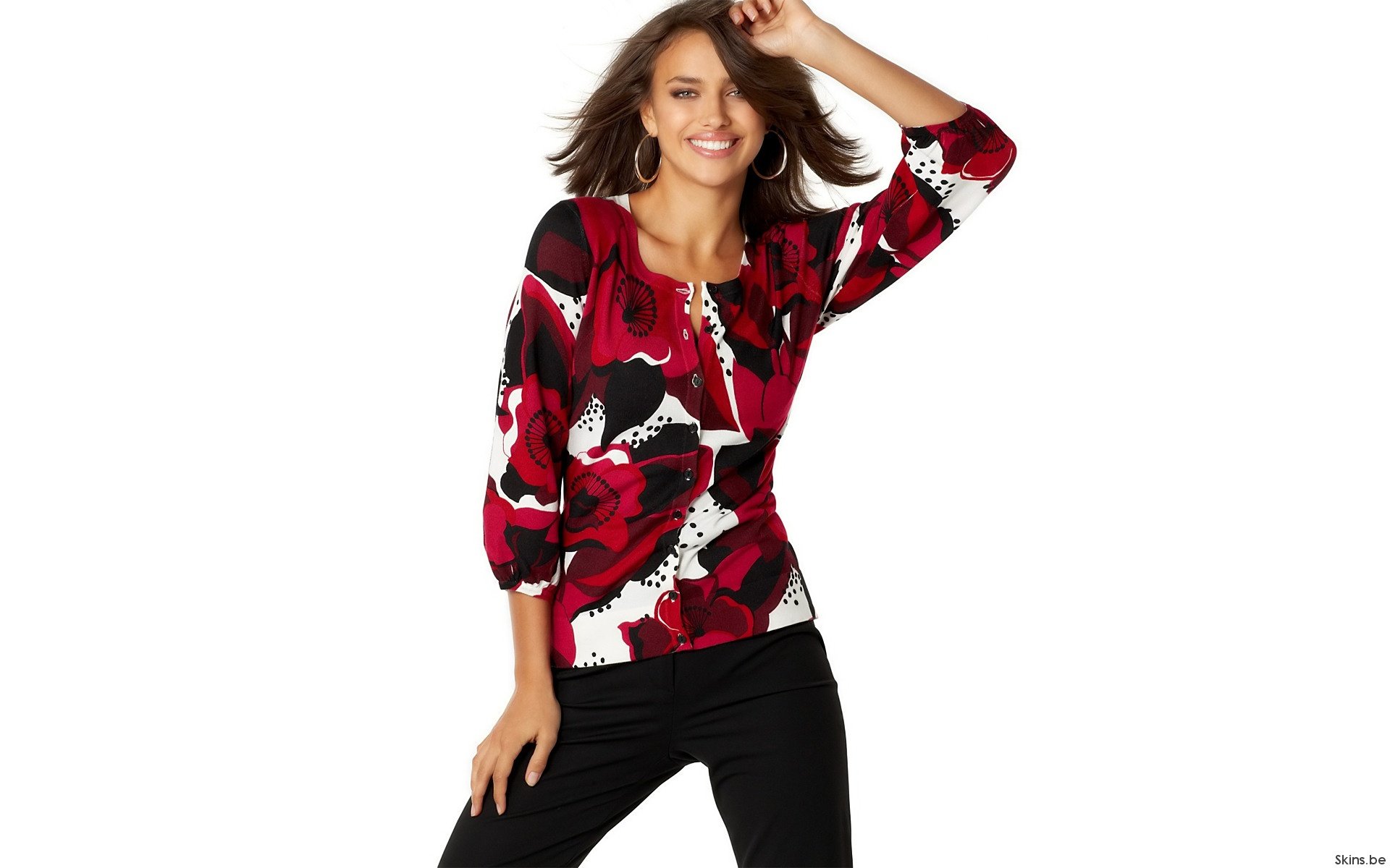 HD PC desktop wallpaper featuring celebrity Irina Shayk smiling in a red, black, and white patterned top with black pants against a white background.
