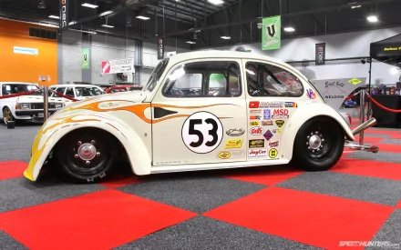 HD PC desktop wallpaper and background: a classic white Volkswagen Beetle vehicle styled as a race car (#53) with sponsor decals and lowered stance on a red-and-gray checkered showroom floor.