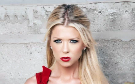 Close-up portrait of Tara Reid, featuring her striking blue eyes and bold red lips, set against a textured gray background. A vibrant and stylish HD desktop wallpaper.
