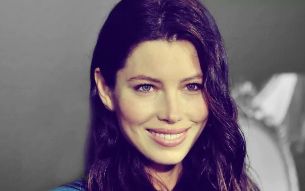 HD wallpaper featuring Jessica Biel, showcasing her radiant smile and long dark hair against a softly blurred background. A captivating desktop backdrop for fans.