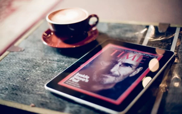 HD desktop wallpaper featuring an iPad displaying a TIME magazine cover, accompanied by a coffee cup on a textured surface, highlighting technology and modern lifestyle.
