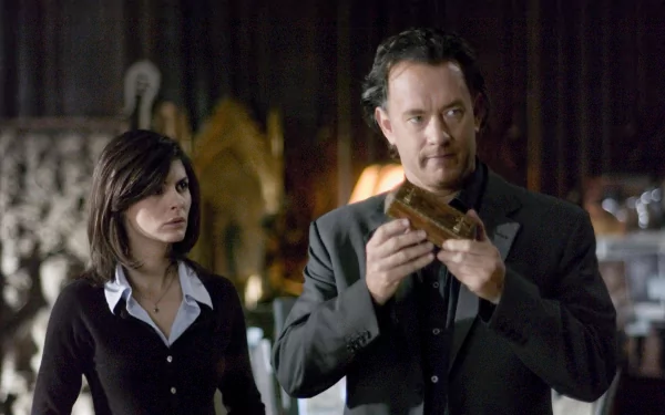 HD desktop wallpaper featuring characters from The Da Vinci Code with Tom Hanks examining an object and Audrey Tautou observing.
