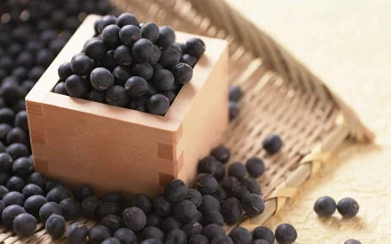 HD PC desktop wallpaper: close-up of fresh blueberries spilling from a wooden box onto a woven tray, food-themed background.