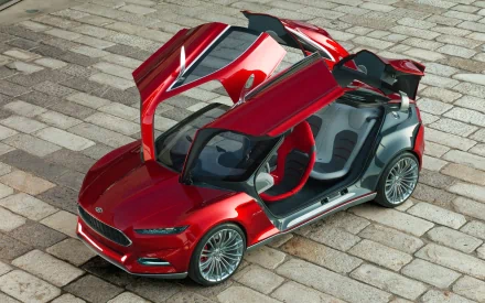 Red 2011 Ford Evos concept vehicle with gullwing doors open, shown as a 2K Quad HD PC desktop wallpaper and background, angled view on cobblestone pavement.