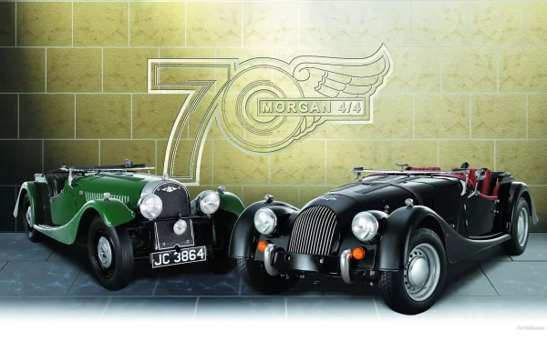 HD PC desktop wallpaper/background: two vintage Morgan vehicles — green and black roadsters — parked before a tiled wall with a large 70 Morgan emblem.
