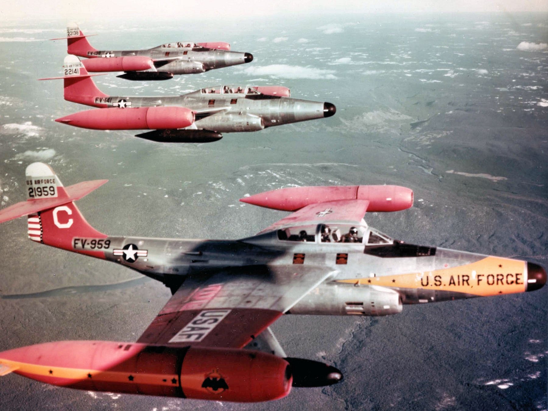 HD desktop wallpaper showing a formation of U.S. Air Force military aircraft flying above a cloudy landscape.