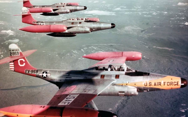 HD desktop wallpaper showing a formation of U.S. Air Force military aircraft flying above a cloudy landscape.