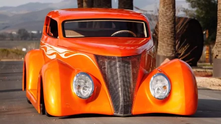 HD desktop wallpaper featuring a vibrant orange 1937 Ford sedan with a sleek, custom design set against an outdoor backdrop.