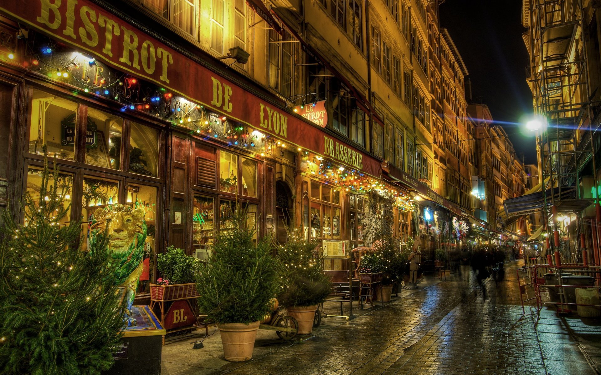 HD desktop wallpaper showcasing a vibrant time-lapse photograph of a bustling, warmly lit street with restaurants and lively nighttime ambiance.