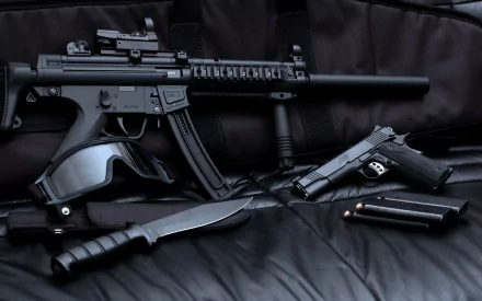 A high-definition wallpaper featuring a submachine gun and a pistol, accompanied by a knife and ammunition, set against a dark, textured background.