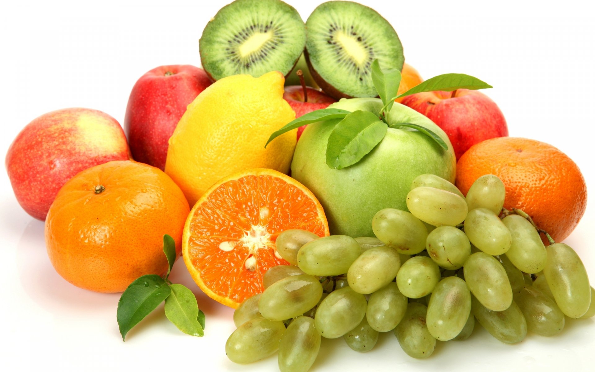 Bright assortment of oranges, grapes, kiwi, apples and lemon on white — crisp 2K Quad HD PC desktop wallpaper and background.