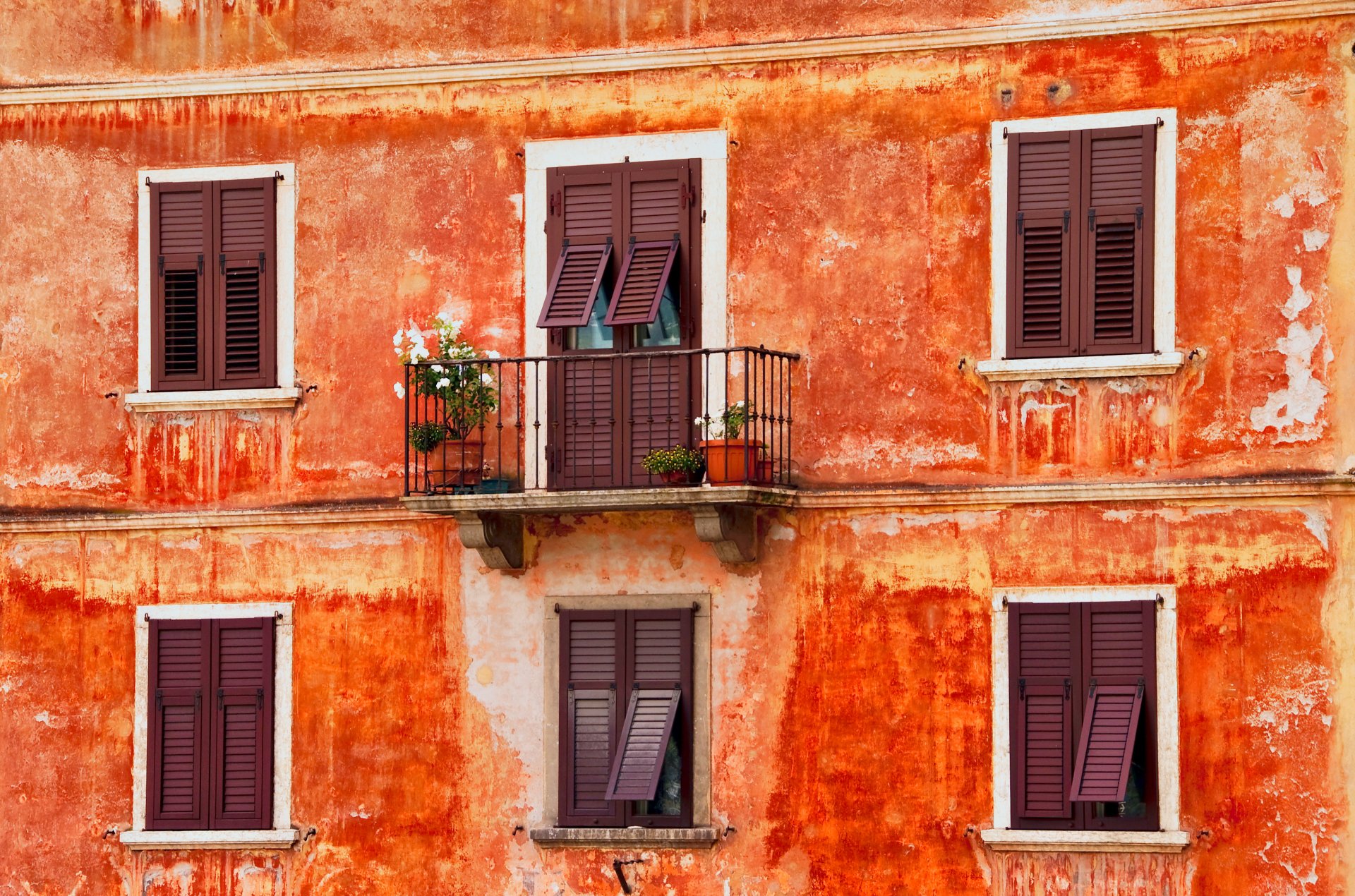 2K Quad HD PC desktop wallpaper and background: weathered orange stucco façade with shuttered windows and a small balcony with potted plants (man-made, balcony)