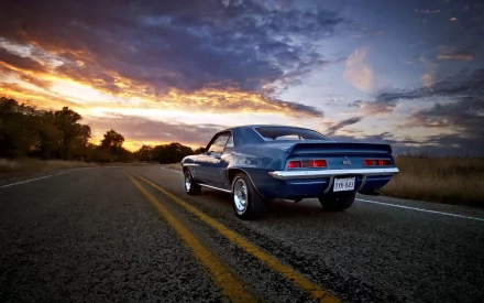 HD desktop wallpaper of a Chevrolet Camaro SS parked on a road at sunset, featuring a dramatic sky and vibrant colors.