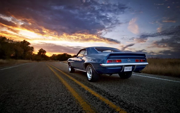 HD desktop wallpaper of a Chevrolet Camaro SS parked on a road at sunset, featuring a dramatic sky and vibrant colors.