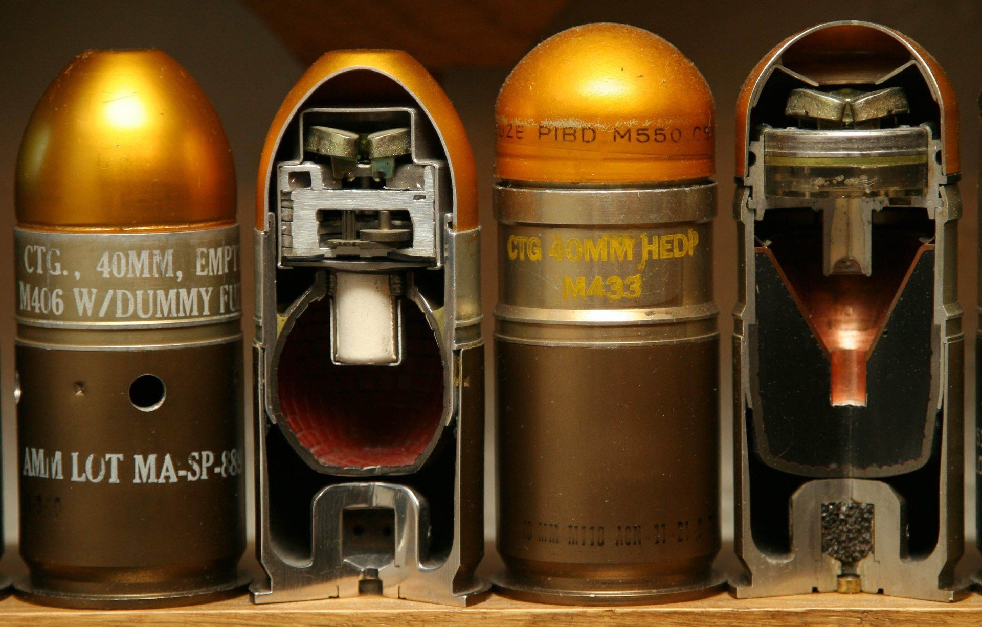 A close-up view of four man-made bullets, showcasing their cutaway designs and intricate interiors, set as a high-definition PC desktop wallpaper and background.