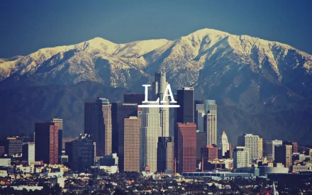 A stunning HD desktop wallpaper showcasing the Los Angeles skyline with snowy mountains in the background, capturing the vibrant essence of the city.