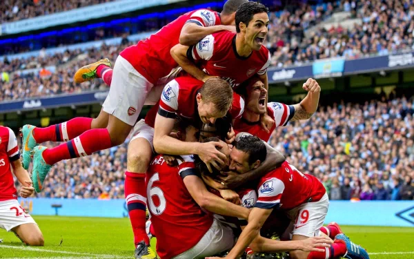 Arsenal F.C. players celebrate a goal in a packed stadium, captured in this HD PC desktop wallpaper showcasing the spirit of FC Arsenal and their dynamic gameplay.