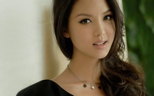 A high-definition wallpaper featuring Zhang Zilin, showcasing a beautiful woman with long dark hair and a charming expression, against a softly blurred background. Great for enhancing a desktop's visual appeal.