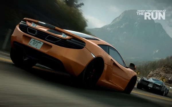 HD PC desktop wallpaper featuring a high-speed orange sports car racing on a mountain road from the video game Need For Speed: The Run.