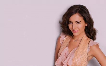 HD wallpaper featuring celebrity Camilla Belle, showcasing her in a stylish outfit with a soft pink backdrop.