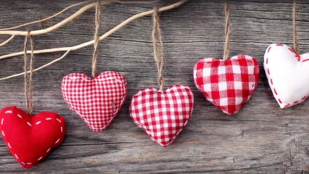 HD desktop wallpaper featuring red and white fabric hearts hanging on twine against a rustic wooden background, celebrating Valentine's Day holiday.