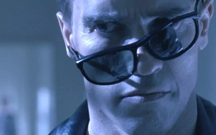 A close-up of a character from the movie The Terminator, featuring intense expression and sunglasses, captured in a high-definition PC desktop wallpaper.