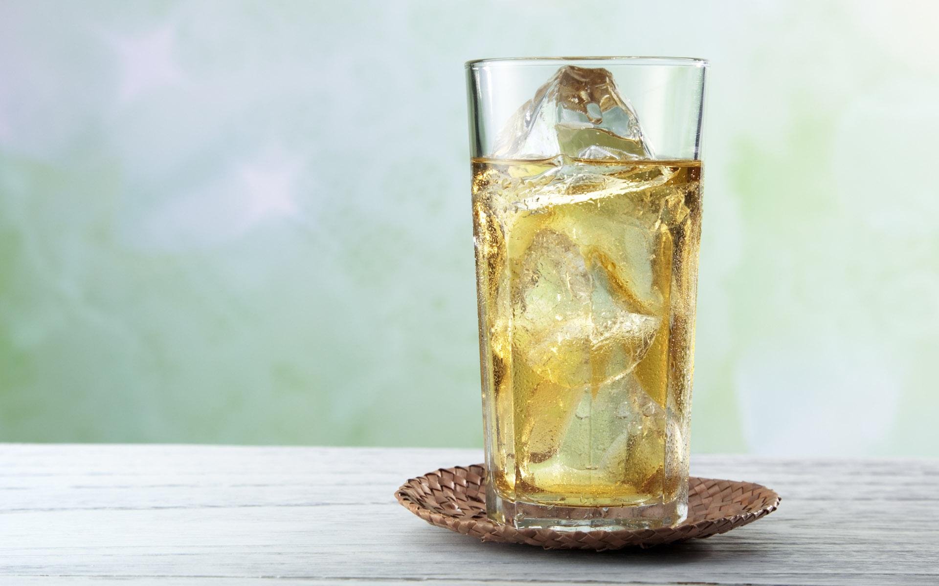 HD PC desktop wallpaper showing a refreshing glass of iced drink on a small woven coaster against a soft, blurred background.