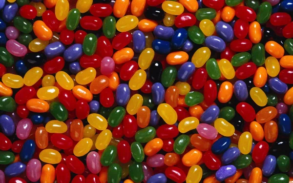 A vibrant HD desktop wallpaper featuring a colorful assortment of jellybeans in various shades, creating a fun and lively food-themed background.