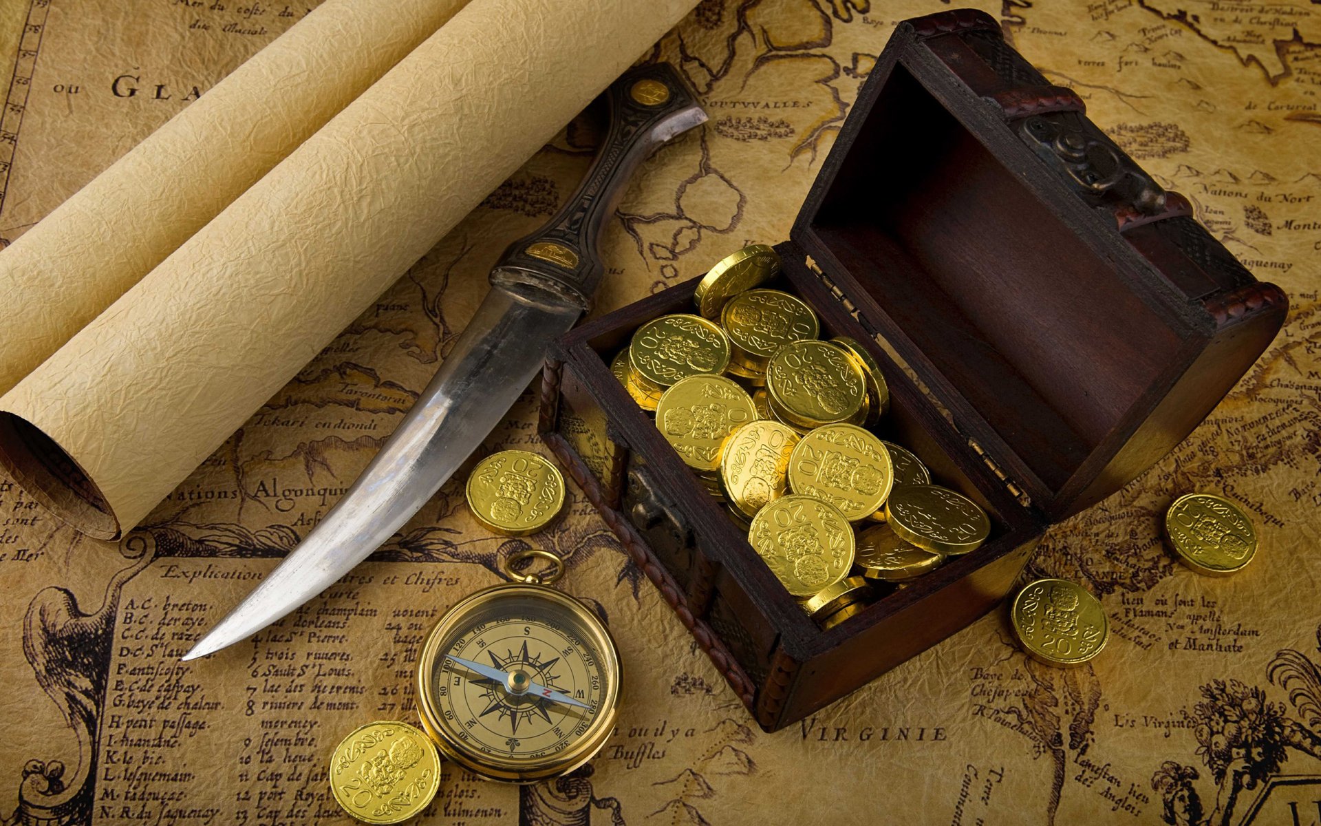 HD PC desktop wallpaper depicting a man-made treasure scene with gold coins spilling from a chest, a compass, a knife, and old maps for a vintage adventure theme.