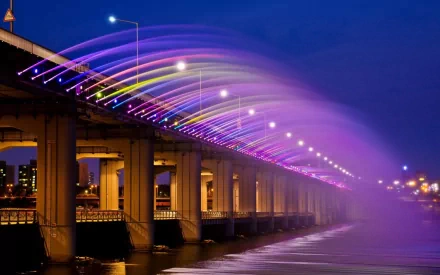 Man-made Banpo Bridge at night with rainbow-colored illuminated fountain arches cascading over the river — HD PC desktop wallpaper/background.