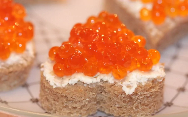 2K Quad HD PC Desktop Wallpaper and Background: close-up food image of rye heart-shaped canapés spread with cream cheese and topped with glossy orange caviar.
