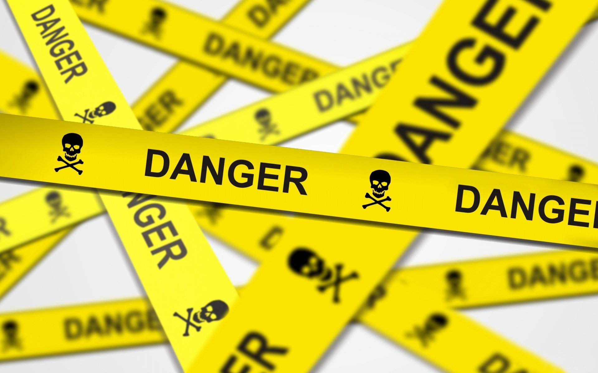 A vibrant HD desktop wallpaper featuring yellow caution tape with bold DANGER text and skull icons, delivering a striking warning and a sense of urgency.