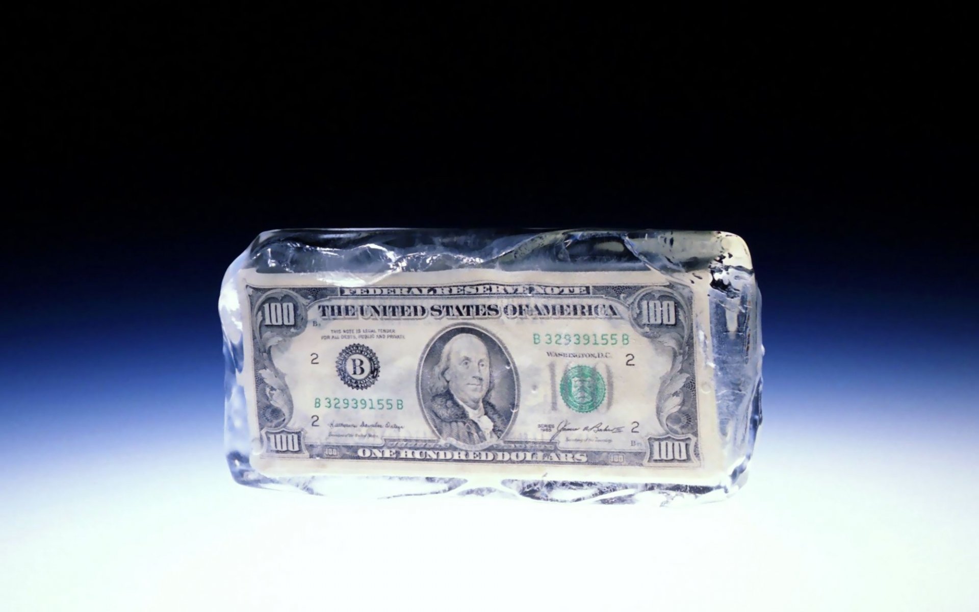 HD desktop wallpaper featuring a man-made $100 bill frozen inside a clear block of ice, symbolizing money and value preservation.