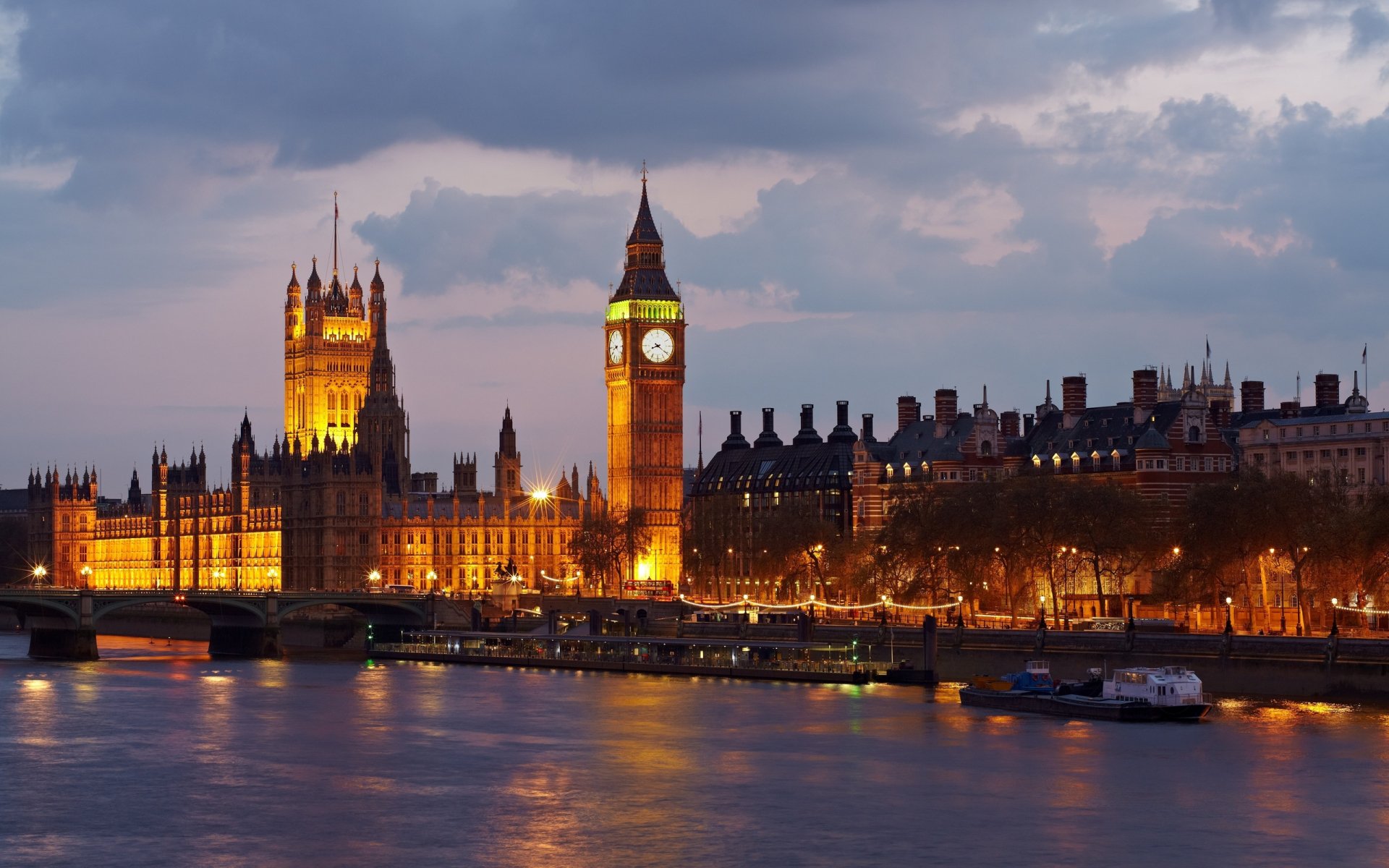 HD desktop wallpaper featuring a view of London’s iconic Big Ben and the illuminated Palace of Westminster along the river at dusk.