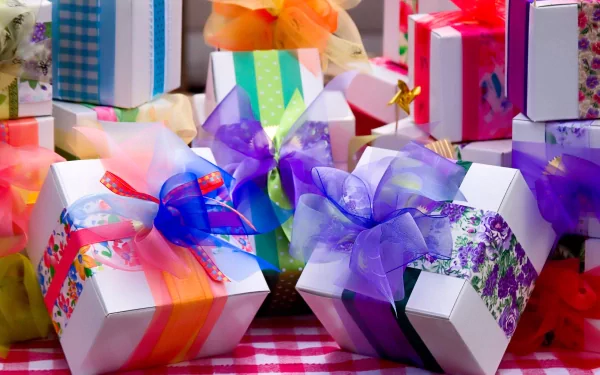 A vibrant HD PC desktop wallpaper featuring beautifully wrapped gift boxes adorned with colorful ribbons, set against a cheerful checkered background.
