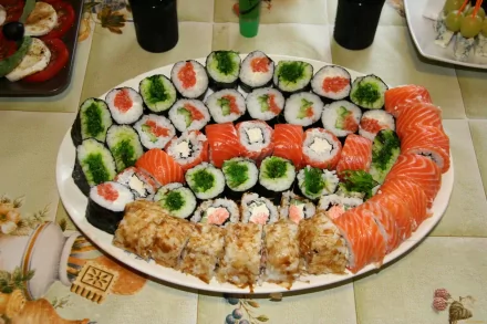 HD PC desktop wallpaper featuring a vibrant platter of assorted sushi rolls with fresh salmon, cucumber, and crab on a table setting.