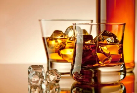 4K Ultra HD desktop wallpaper featuring two glasses of whisky with ice cubes, accompanied by additional ice and a bottle in the background, highlighting food and whisky themes.