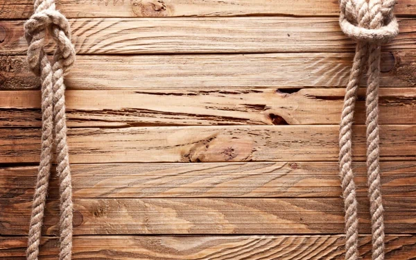 HD desktop wallpaper featuring an artistic wooden texture with ropes tied in knots at the top corners. The warm tones and intricate wood grain create a natural and rustic background.