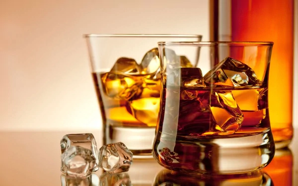4K Ultra HD desktop wallpaper featuring two glasses of whisky with ice cubes, accompanied by additional ice and a bottle in the background, highlighting food and whisky themes.