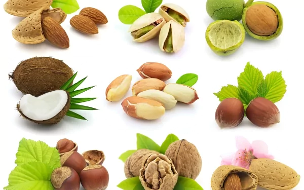 A vibrant 4K Ultra HD PC desktop wallpaper featuring an array of nuts, including almonds, pistachios, and macadamia nuts, beautifully arranged with green leaves.