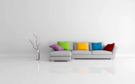 Artistic HD PC desktop wallpaper depicting modern furniture with a minimalist gray sectional sofa adorned with colorful cushions against a clean white wall.