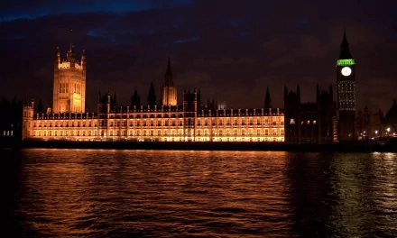4K Ultra HD image of the illuminated Houses of Parliament and Big Ben reflected on the River Thames in London at night, showcasing iconic man-made architecture.