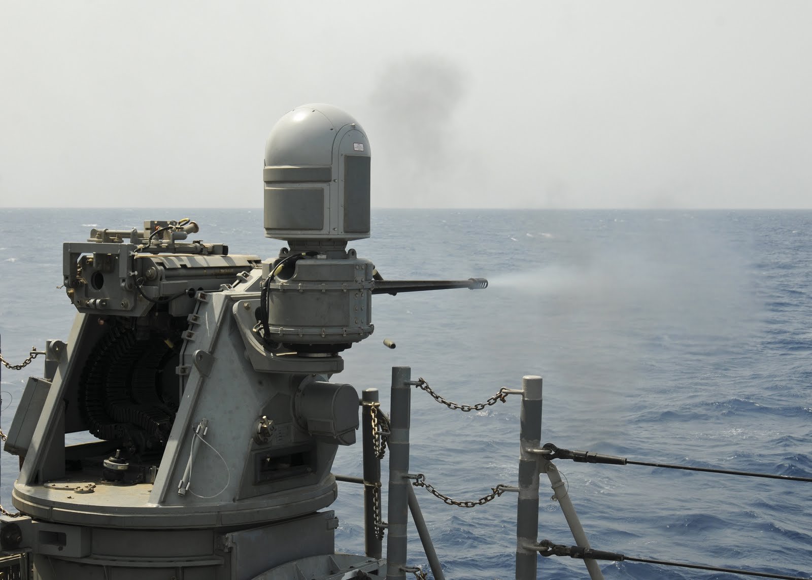 HD desktop wallpaper showing a navy ship equipped with a MK-38 25mm machine gun overlooking the ocean.