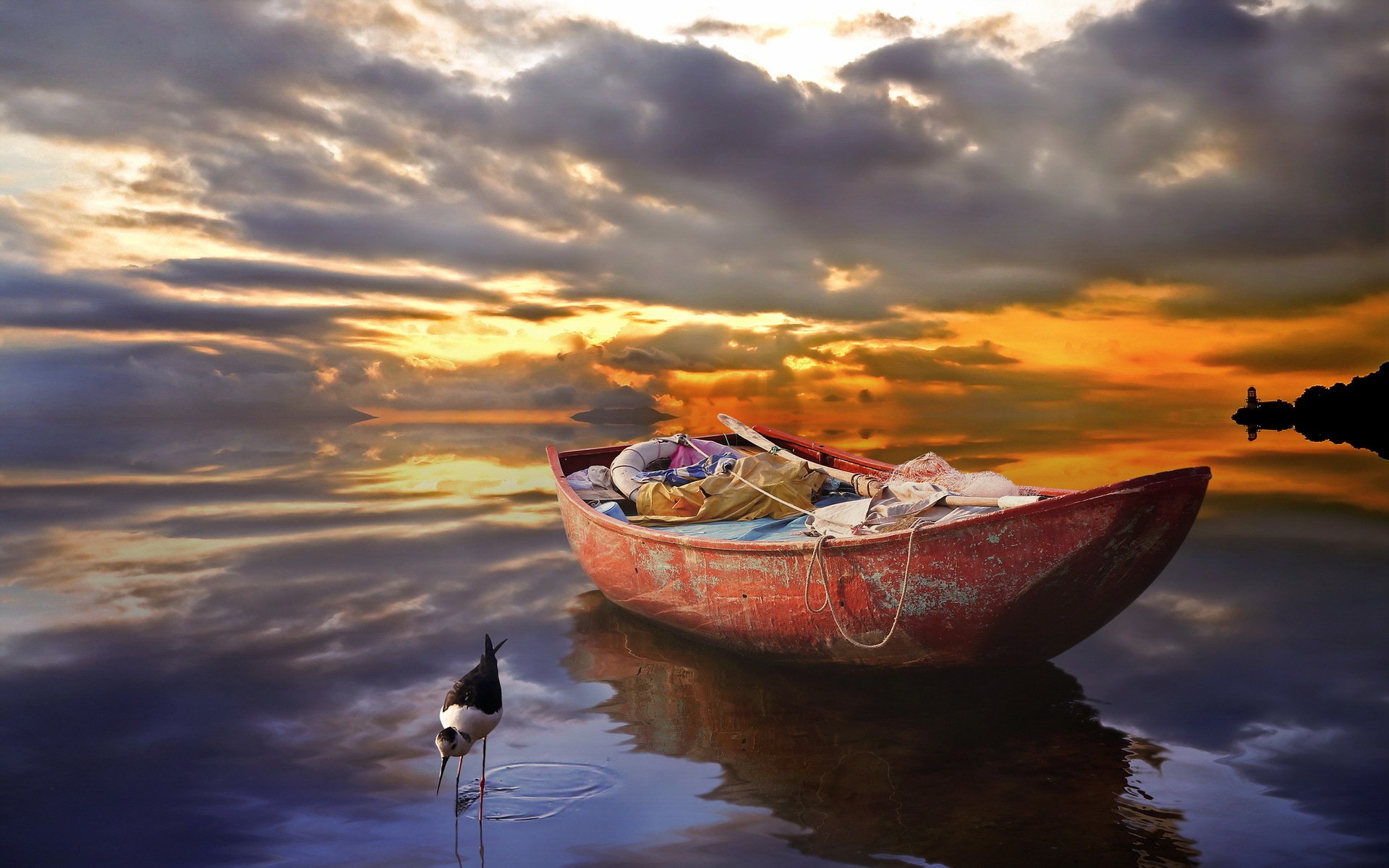 HD desktop wallpaper of a small boat floating on calm water during a dramatic sunset with clouds reflecting on the surface.