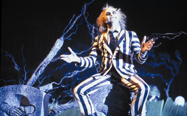 HD desktop wallpaper featuring Michael Keaton as Beetlejuice in his iconic black-and-white striped suit with an electrifying graveyard background.